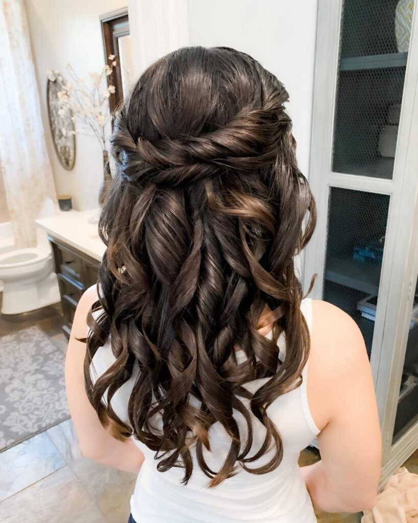 Curly brown hair styled in a half-updo with a twisted braided back section.