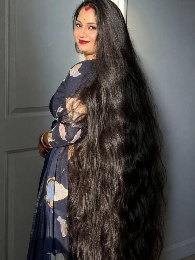 Woman with wavy black hair extending from her head down to the floor.